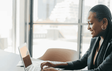 Woman studying for the Series 66 license exam on a laptop in a modern office