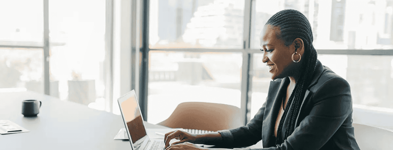 Woman studying for the Series 66 license exam on a laptop in a modern office