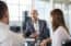 Financial planner discussing career options with a couple in a modern office setting – representing the financial planner vs analyst decision-making process