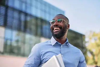 man smiling in front of a building