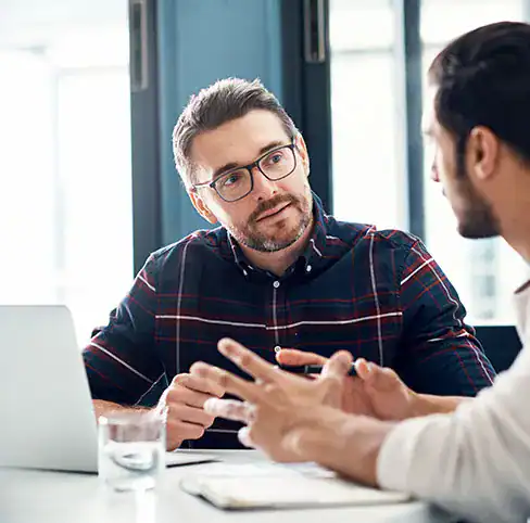 two people talking at a desk